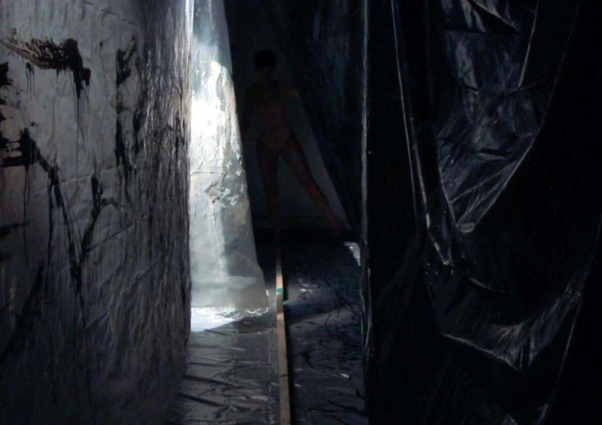 Balancing beam between two sheets of plastic that are covered in paint.