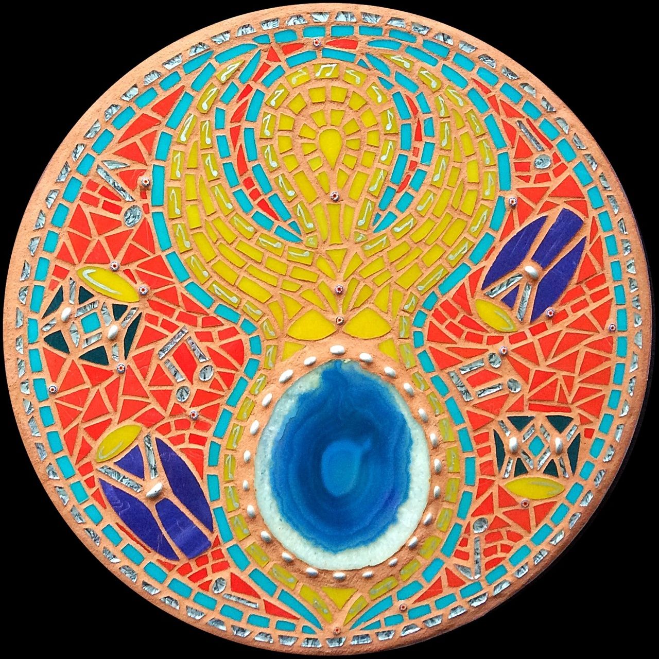 Rossana Reis' Deusx 6, a brightly colored circular mosaic of a figure with a blue belly surrounded by drums.