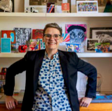 A photo of Tabitha Jacques wearing a navy blazer and blue polkadot shirt.